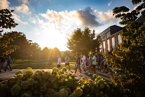 University of Kentucky students walk across campus at sunset on their way to attend an event.