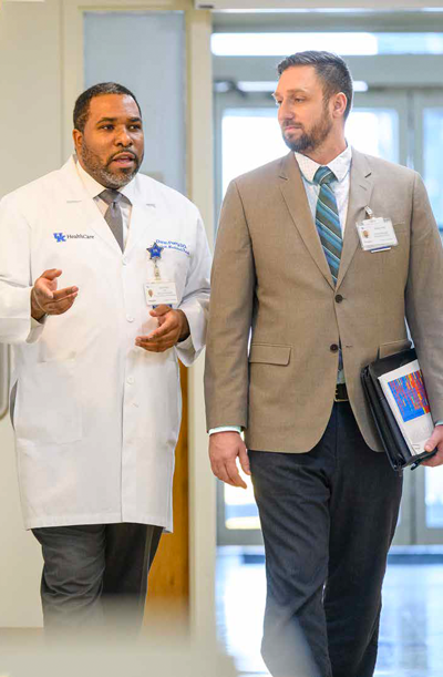 A doctor and administrator talk as they walk through the hospital.