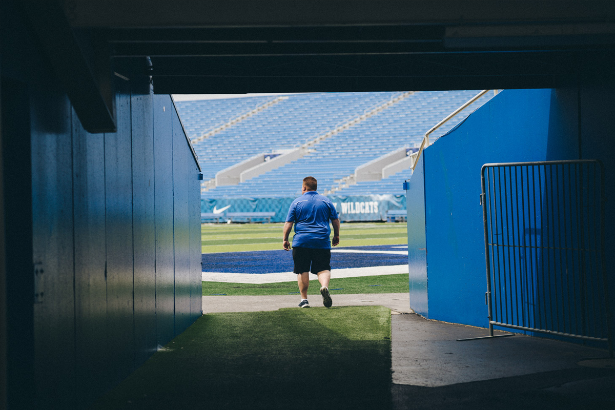 Jimmy Rhoades walks onto the football field.