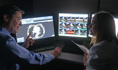 John Gurley, MD discusses a scan with Kate Moore, PA-C.