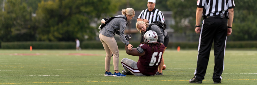 Athletic trainers assist an injured football player.