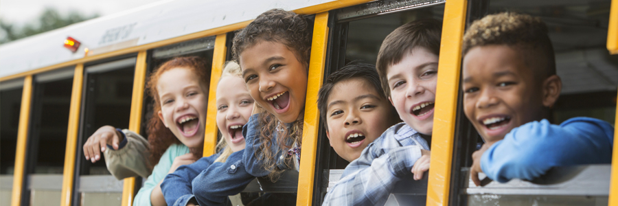 Kids lean out of school bus windows.