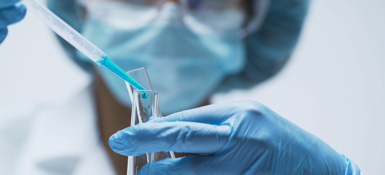 Researcher adds drops of blue substance into test tube