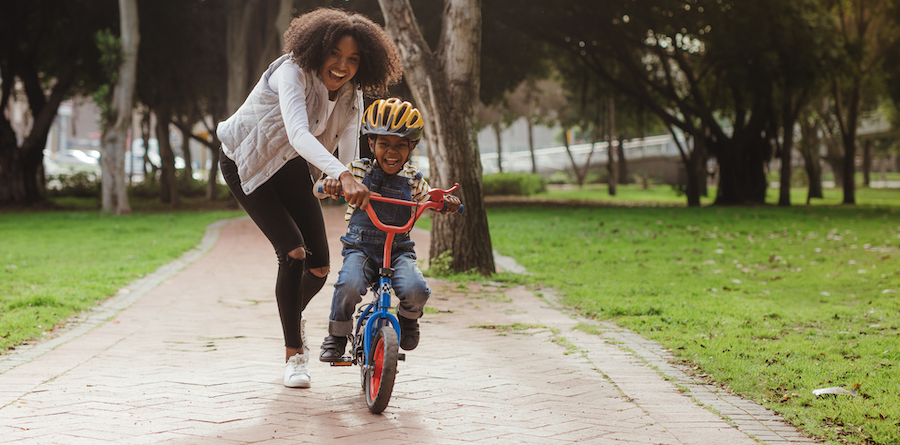 Mother teaching her son to ride a bicycle.