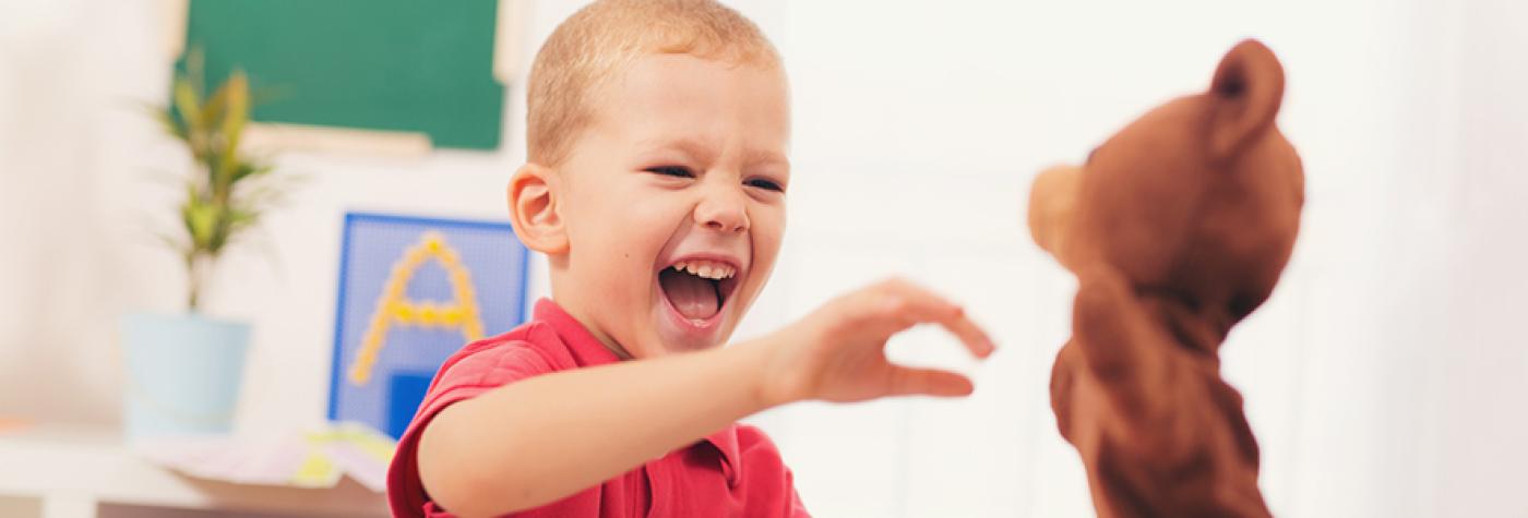 Boy laughing at puppet