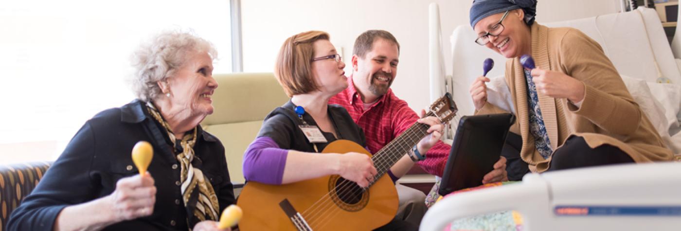 A patient and her family participate in music therapy.
