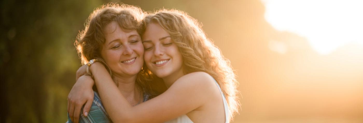 A teenage girl hugs her mother
