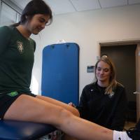 Brooke Dawahare, left, receives instruction from former UK HealthCare athletic trainer Taylor Spyker.
