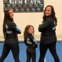 Izzy poses with two of the adult Gem Cat gymnasts.