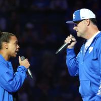 Amber and Coach Mitchell, dressed in UK jackets, both holding microphones and talking to each other during Big Blue Madness.