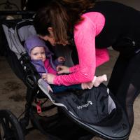 Amberlee buckles Anna in her stroller before going for a jog.