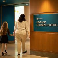 Audrey and Tiv walking next to a Kentucky Children's Hospital sign