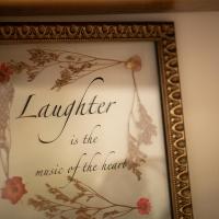 A framed quote that reads Laughter is the Music of the Heart