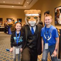 Izzy and Dalton pause for a photo with the UK Wildcat mascot in a suit.