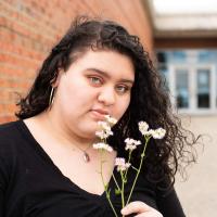 Faith holds a flower outside of her high school.