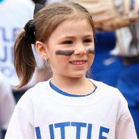 A close-up photo of Kailey on the softball field with black stripes painted on her cheeks.