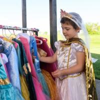 Leorah admires a rack of her costumes while wearing one herself.