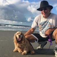While at the beach, Gary wears a wide-brimmed hat and squats and poses for the camera with the family dog Calipari, a light brown Spaniel.
