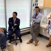 Dr. Kim, along with two of his colleagues, talks with Gary in an exam room.