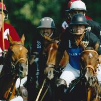 A group of horseback polo players, including Omar, huddled together on their horses mid-match.