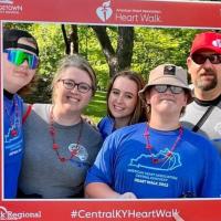A photo of the entire Mullins family posing together for a photo with a cutout from the American Heart Association’s Heart Walk.