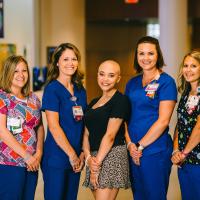 Savannah poses for a photo with four nurses from her care team.