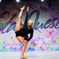 Savannah dances on stage in a black, longsleeved, leotard at StarQuest Dance Competition.