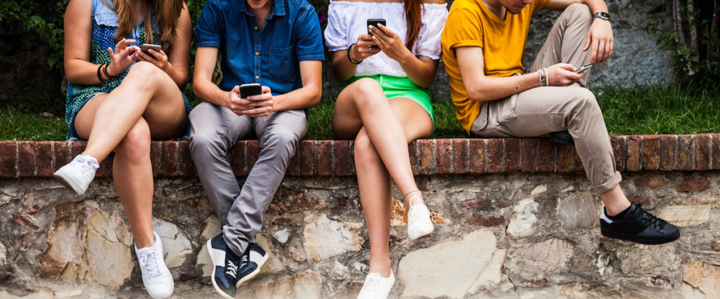 Teens using their cellphones.