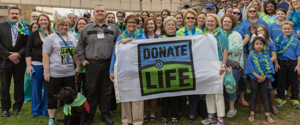 A large group of UK employees holding a Donate Life banner.